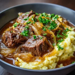 Karamelliserad lök- och köttgryta med mört nötkött och fyllig sås, serverad i en skål i ett ljust kök.